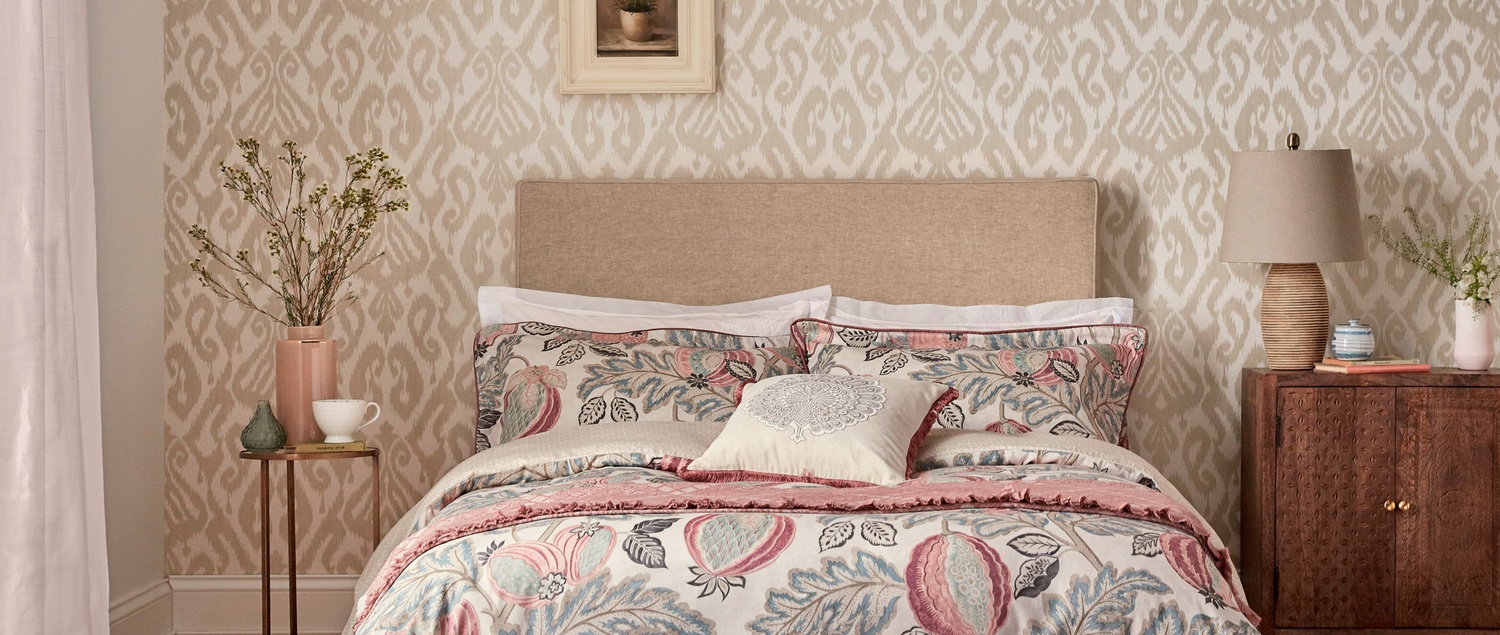 Neutral tone wallpaper with pastel pink bedding in bedroom